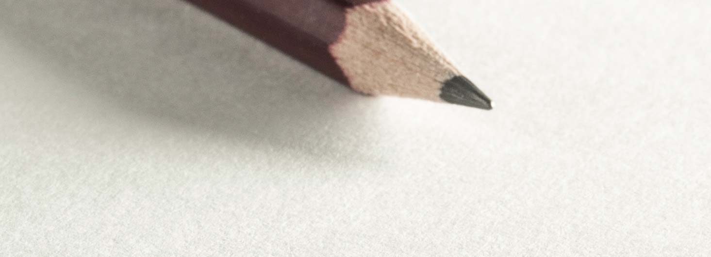 Bleistift mit dünner Mine liegt auf einem weißen Blatt Skizzenpapier