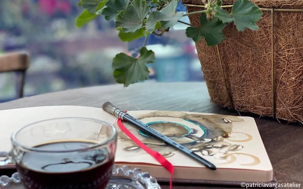 paintbrush, journal, coffee, plant pot, art setup